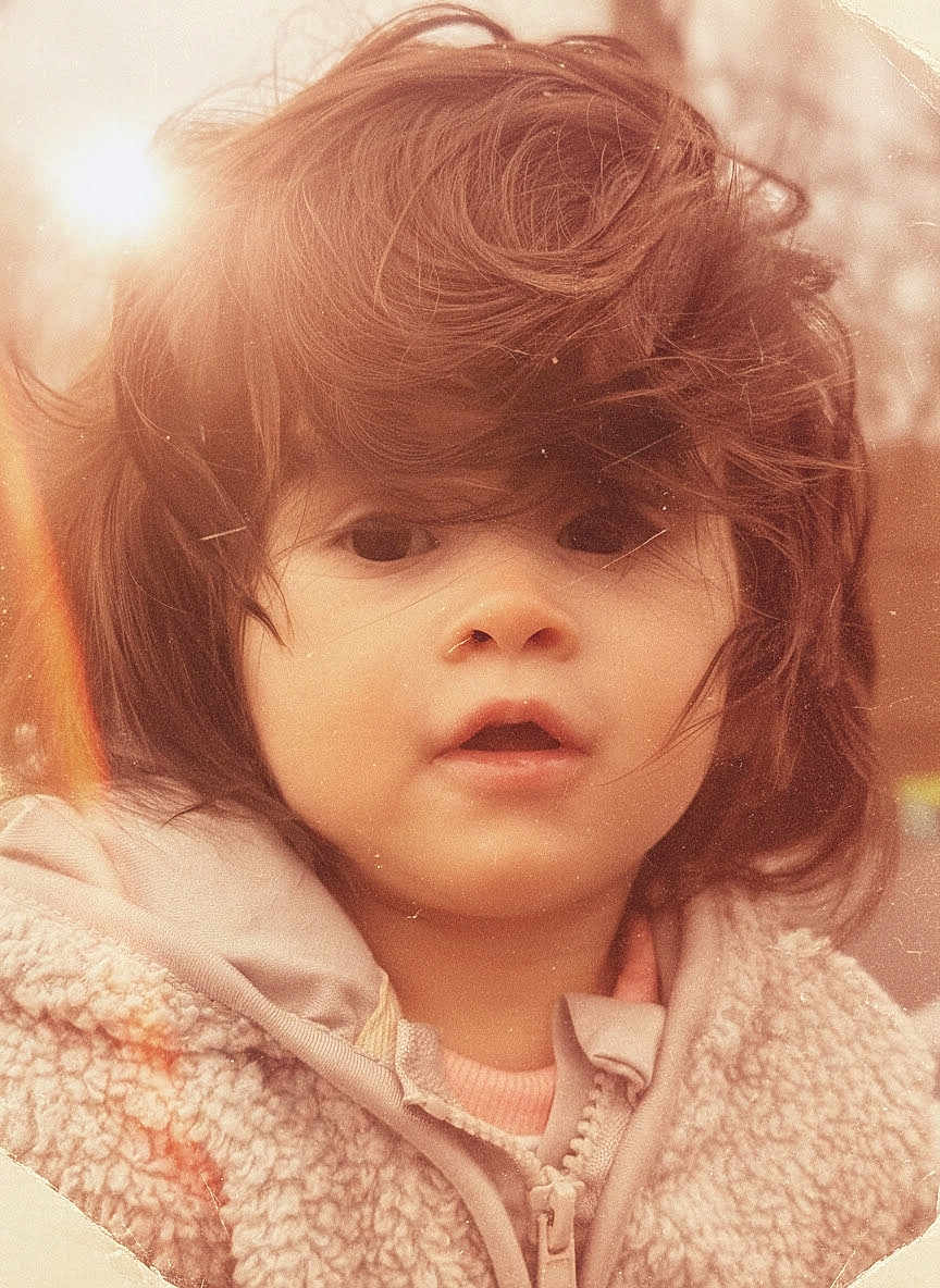 Rubie joined the competition — help win amazing prizes! child, toddler, portrait, closeup, face, eyes, hair, messy_hair, coat, zipper, fleece, hoodie, soft_lighting, sunflare, vintage_filter, warm_tones, candid, outdoors, innocence, expression