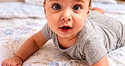 Liam is registered to the contest to win money with this photo: baby, bed, bedding, child, curious, cute, cute_baby, expression, eyes, face, floral_pattern, gray_clothing, hand, head, indoor, infant, portrait, skin, toddler, young_child