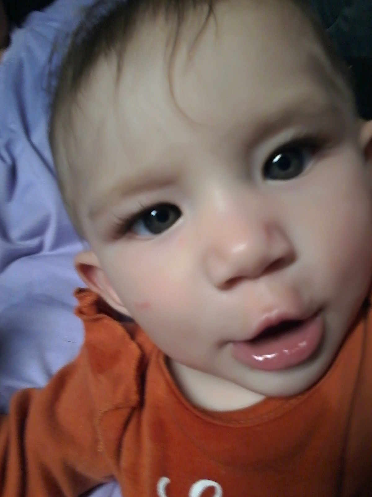 Sharon is registered to the contest to win money with this photo: baby, infant, face, closeup, child, curious, orange_clothing, purple_blanket, mouth_open, eyes, skin, head, person, young, portrait, indoor, cute, expression, human, baby_girl