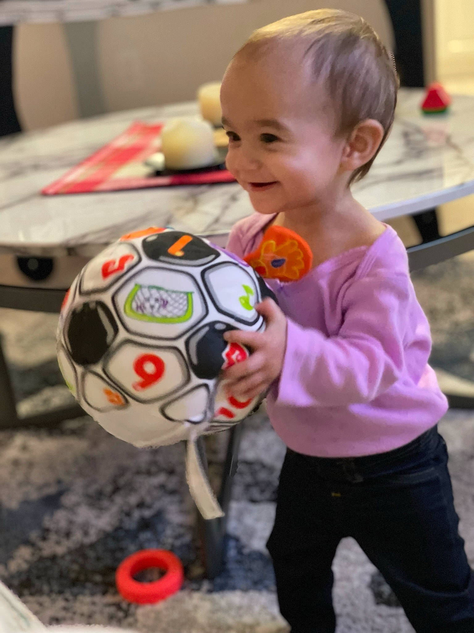 Ava is registered to the contest to win money with this photo: art, baby, baby_toddler_clothing, ball, child, event, flooring, football, fun, happy, head, joy, leisure, person, play, smile, soccer, soccer_ball, sports_equipment, t_shirt