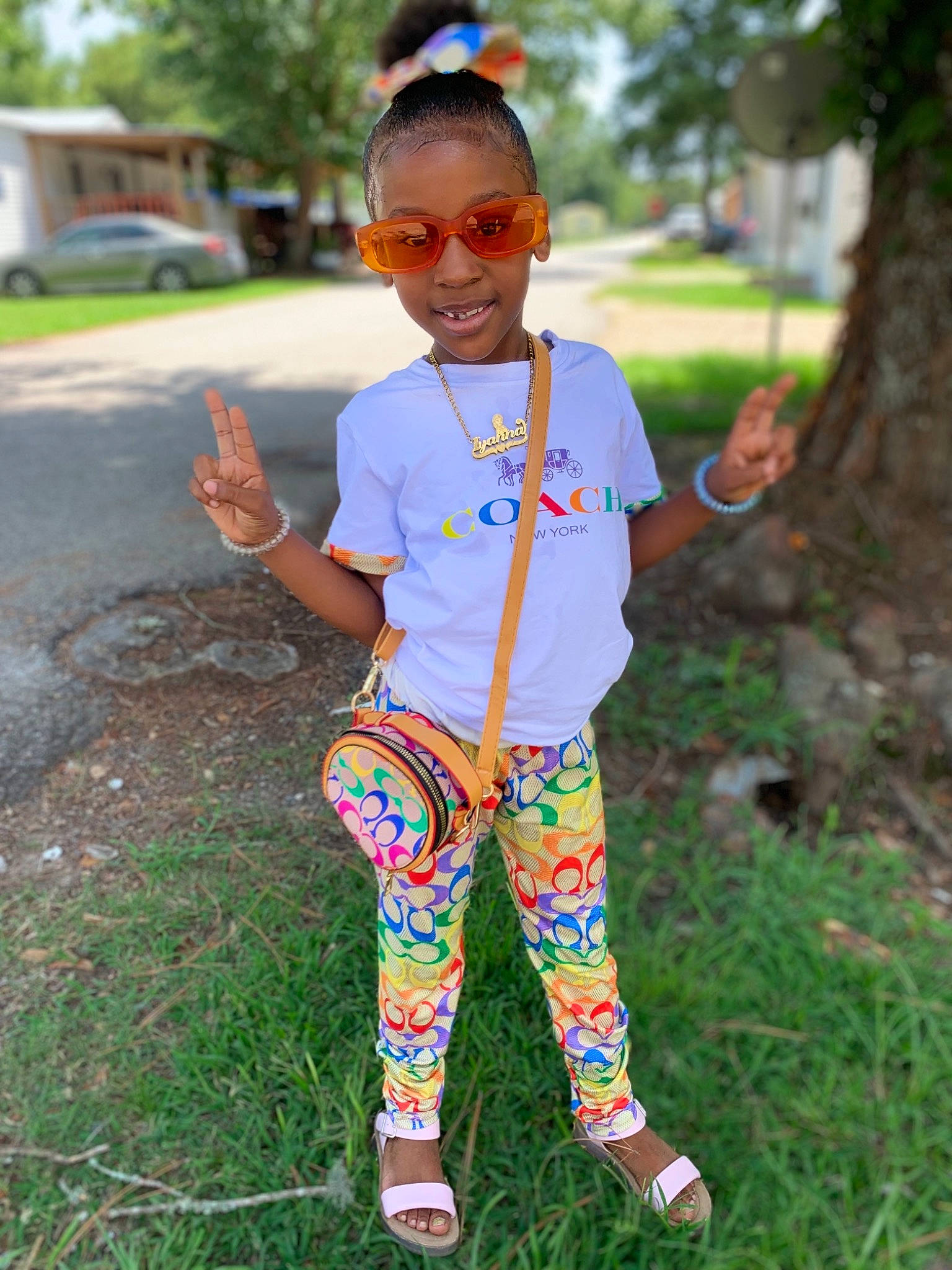 Iyanna is registered to the contest to win money with this photo: child, electric_blue, eyewear, fun, grass, happy, joy, leisure, necklace, pattern, people_in_nature, person, plant, play, recreation, sleeve, smile, t_shirt, toddler, tree