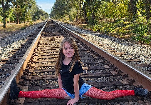 Jocelyn is registered to the contest to win money with this photo: fun, grass, happy, human_leg, joy, knee, leisure, line, people_in_nature, person, plant, railway, shoe, sky, smile, symmetry, thigh, thoroughfare, track, travel