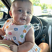 Chevelle joined the competition — help win amazing prizes! baby, child, person, car_interior, steering_wheel, dashboard, window, trees, sunlight, colorful_clothing, flower_pattern, arm, seat, keys, side_mirror, happy, cute, portrait, infant, smile