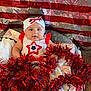baby, infant, red_tinsel, festive_clothing, headband, star_pattern, blanket, sparkly_backdrop, celebration, cute, portrait, indoors, holiday_decor, smiling, chubby_cheeks, decorative, bright_colors, soft_texture, seated, adorable