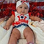 Chevelle is registered to the contest to win money with this photo: baby, infant, child, blanket, red_white_blue, headband, socks, floor, wood_floor, decorations, flag, patriotic, cute, portrait, sitting, indoors, holiday_theme, clothing, face, expression