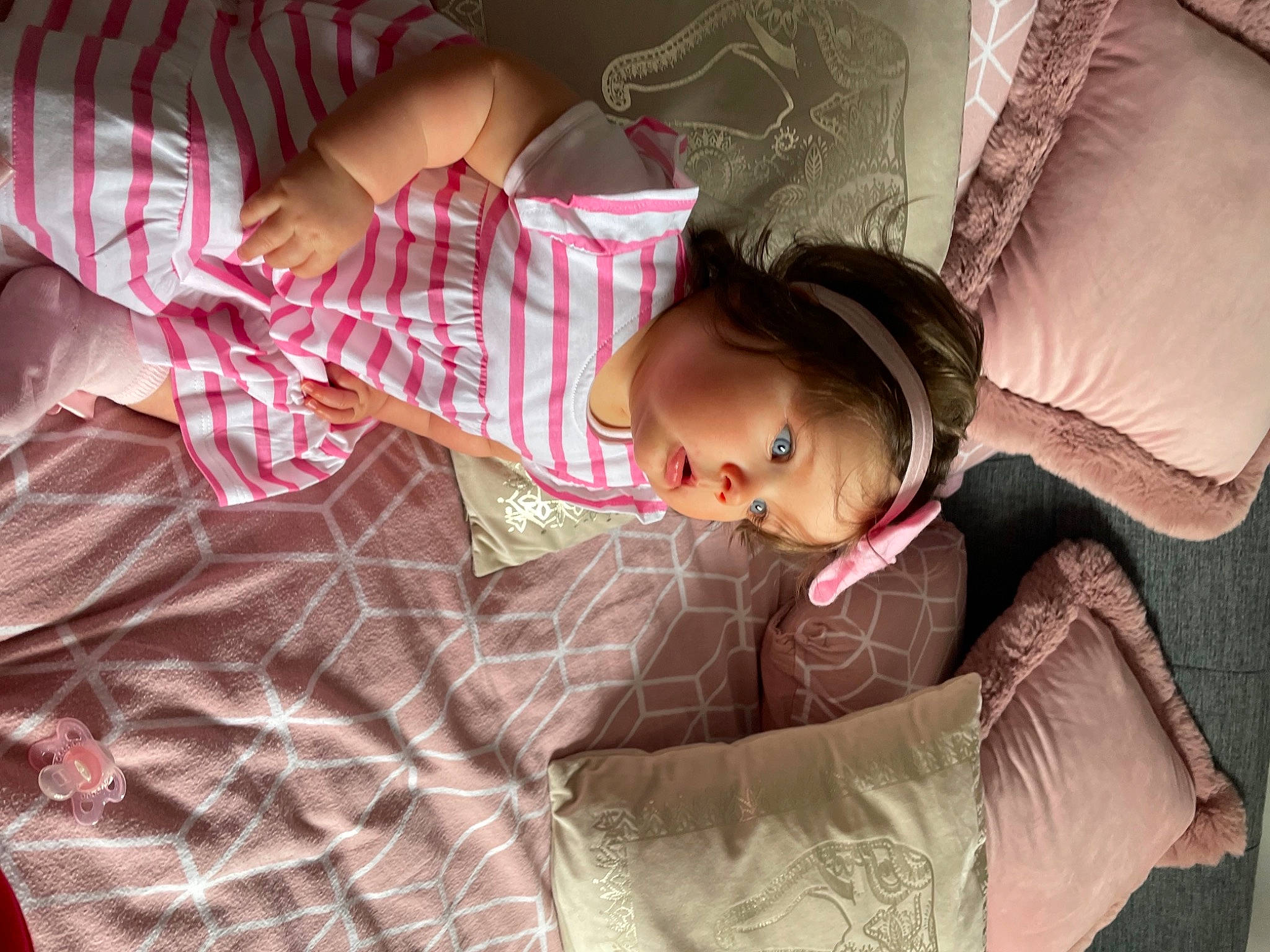 Sofia-rose is registered to the contest to win money with this photo: bed, bedding, child, comfort, couch, dress, eyelash, happy, head, human_body, linens, magenta, pattern, person, pink, plant, purple, skin, sleeve, textile
