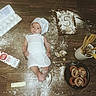 Roman is registered to the contest to win money with this photo: baby, baking, birthday, cake, chef_hat, child, cooking_utensils, eggs, flour, food, homemade_baking, infant, kitchen, lying_down, milk, overhead_view, pastries, portrait, white_clothing, wooden_floor