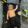 Roman is registered to the contest to win money with this photo: baby, black_blanket, blanket, carpet, child, face, indoor, infant, lying_down, milestone, pants, pliers, portrait, power_drill, screwdriver, smiling, three_months, tools, wooden_sign, workshop