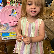 Zoey joined the competition — help win amazing prizes! toddler, child, indoor, dress, pastel_colors, chalk, toy, pink_sweatshirt, cartoon_character, furniture, couch, wooden_table, messy_hair, person, floor, clutter, hand, face, smile, young_child