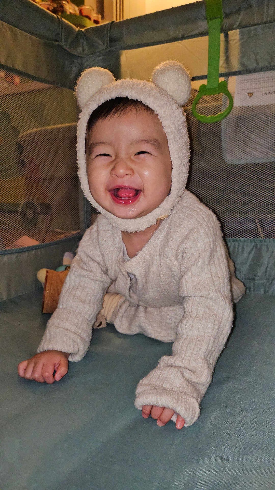 Huynh a rejoint le concours — aidez-le/la à gagner de superbes lots ! baby, child, smiling, crawling, hat, bear_ears, sweater, playpen, indoors, cute, happy, face, person, infant, childhood, cozy, warm_clothing, hands, tongue, joy