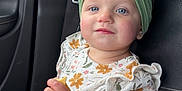Emma is registered to the contest to win money with this photo: toddler, child, car_seat, headband, blue_eyes, snack, floral_outfit, ruffles, rosy_cheeks, soft_lighting, car_interior, seatbelt, black_leather, curious_expression, sitting, portrait, indoor, person, cute, young_child