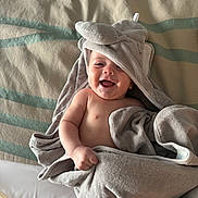 Koen joined the competition — help win amazing prizes! baby, smiling, towel, hood, blanket, striped, happy, child, infant, soft, cute, lying_down, wrapped, skin, indoors, comfort, joyful, expression, face, portrait
