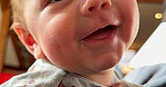 Koen is registered to the contest to win money with this photo: baby, smiling, face, child, infant, cute, eyes, mouth, clothing, indoors, portrait, happy, skin, head, expression, person, cozy, cute_outfit, home_interior, closeup