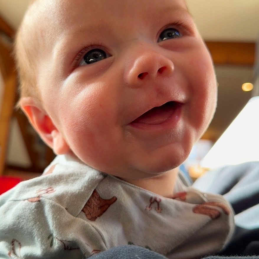 Koen is registered to the contest to win money with this photo: baby, smiling, face, child, infant, cute, eyes, mouth, clothing, indoors, portrait, happy, skin, head, expression, person, cozy, cute_outfit, home_interior, closeup