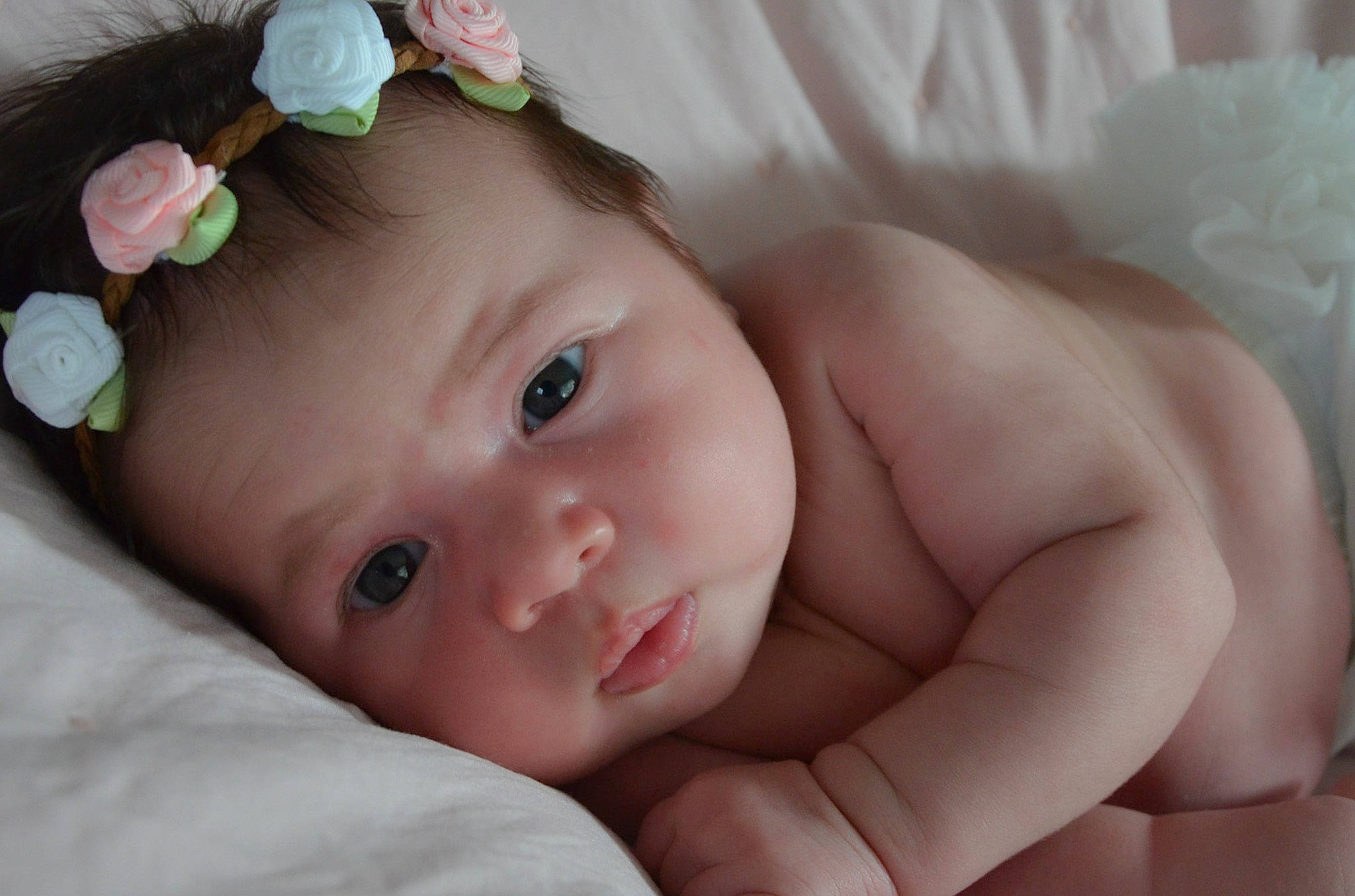 Sunny is registered to the contest to win money with this photo: baby, bedtime, cheek, child, close_up, eye, face, forehead, hair_accessory, head, headband, headgear, iris, lip, mouth, nose, person, photography, pink, skin