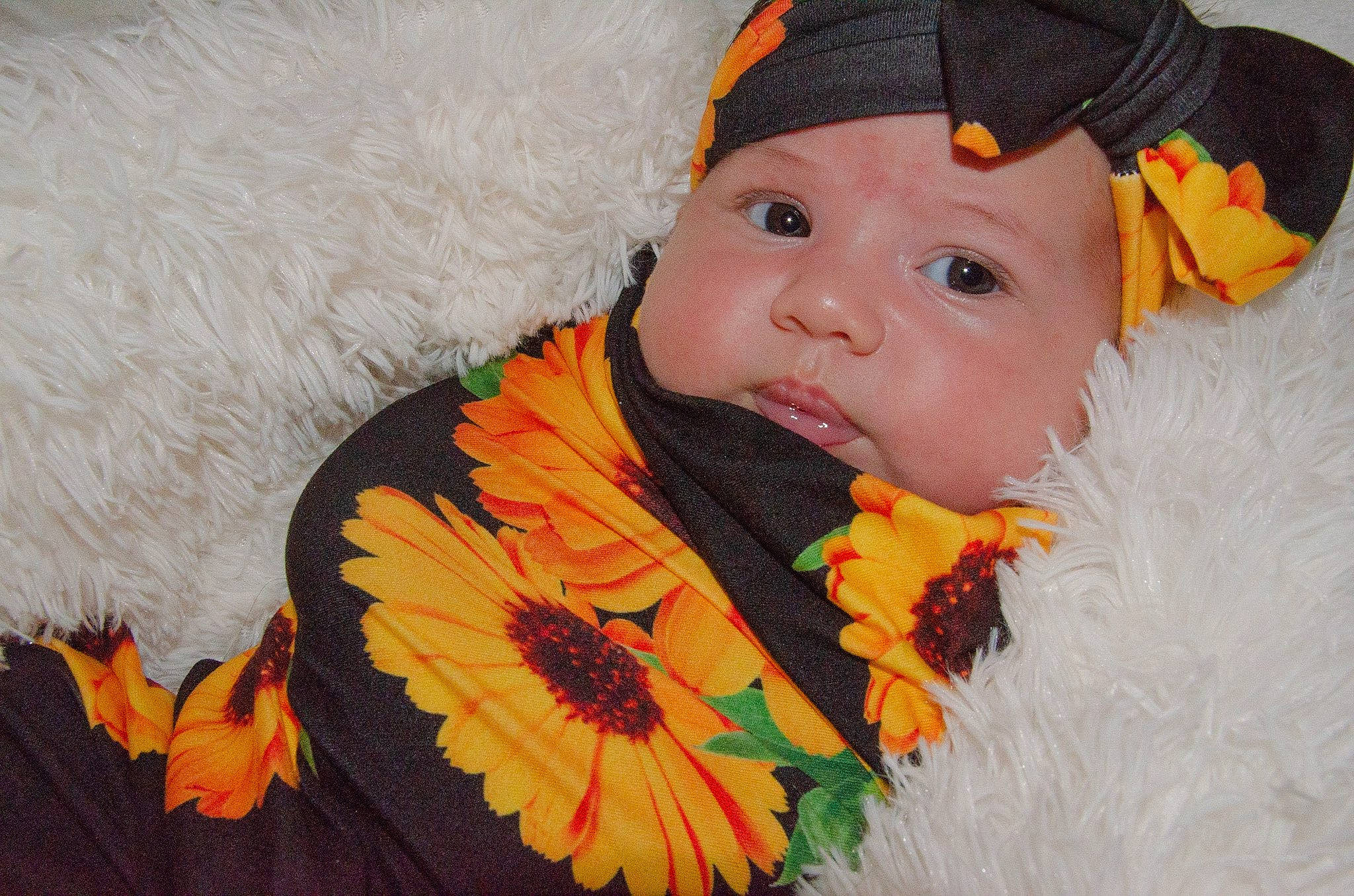 Sunny is registered to the contest to win money with this photo: baby, cheek, child, costume, costume_accessory, fashion_accessory, flower, hair_accessory, headgear, headwear, leaf, person, plant, sunflower, toddler, yellow