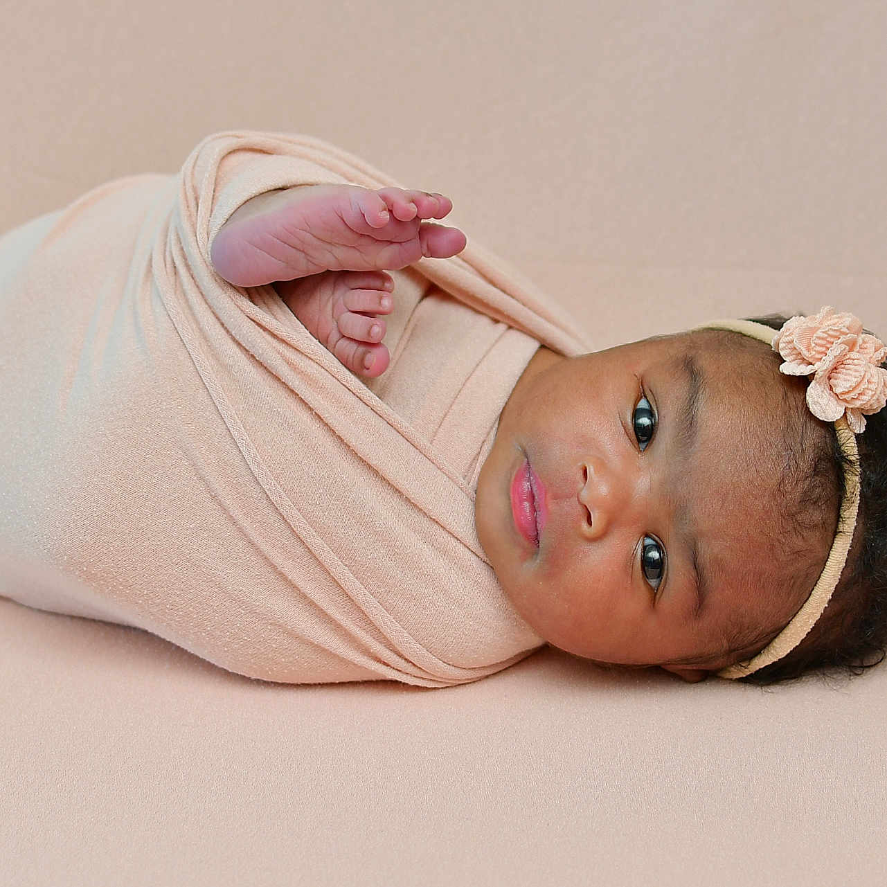 Memunatu is registered to the contest to win money with this photo: adorable, baby, blanket, child, closeup, cute, eyes, face, flower, headband, indoors, infant, lying_down, newborn, peaceful, portrait, skin, soft, swaddled