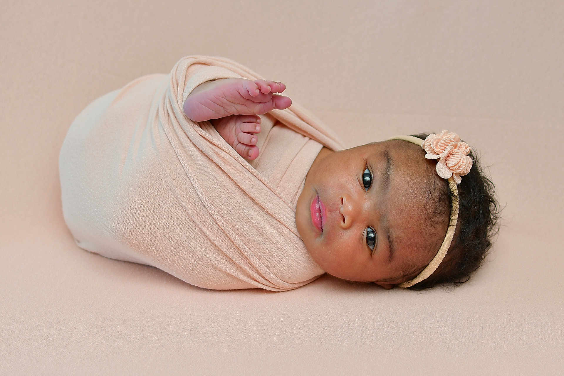 Memunatu is registered to the contest to win money with this photo: baby, infant, swaddled, blanket, headband, flower, newborn, cute, portrait, soft, peaceful, lying_down, skin, face, eyes, closeup, indoors, child, adorable