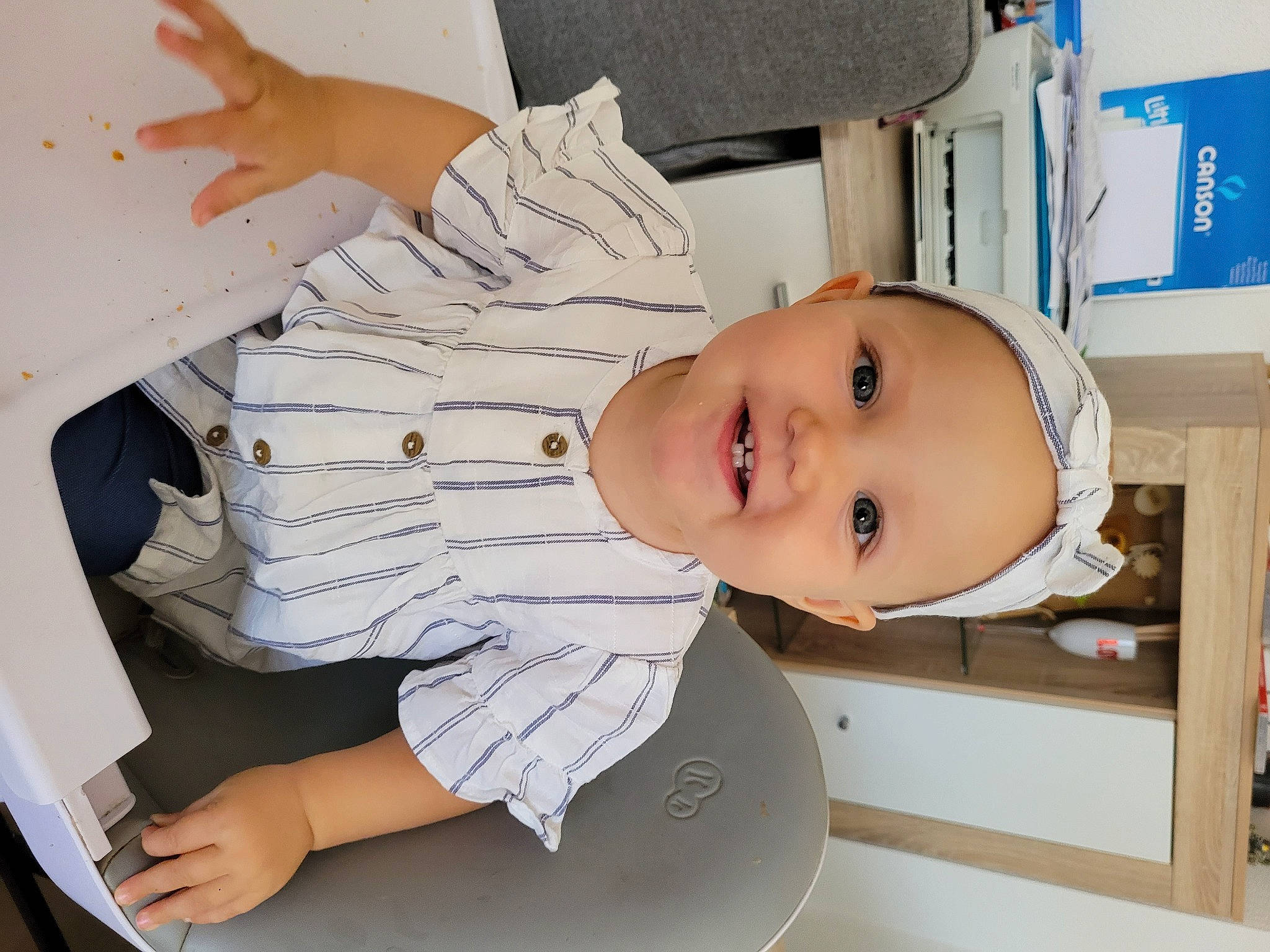 Elyne participe au concours pour gagner de l'argent avec cette photo : baby, baby_toddler_clothing, child, comfort, elbow, gesture, hand, house, joy, person, room, shelf, shelving, sitting, sleeve, smile, standing, t_shirt, thumb, toddler