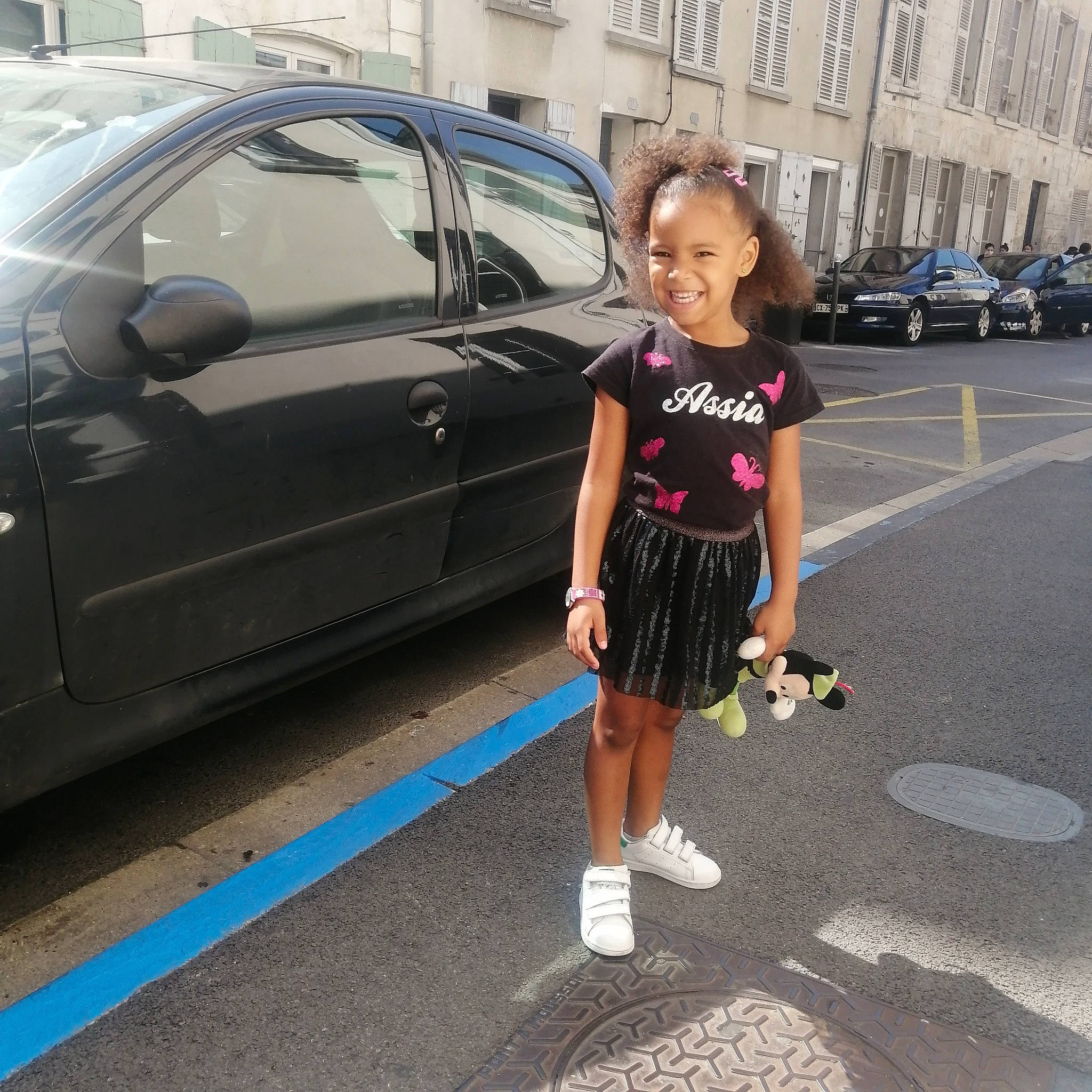 Assia a rejoint le concours — aidez-le/la à gagner de superbes lots ! alloy_wheel, asphalt, automotive_design, automotive_tire, car, dress, footwear, infrastructure, joy, land_vehicle, leg, motor_vehicle, person, plant, road, shoe, smile, standing, street_fashion, tire