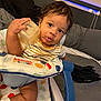 Dandre is registered to the contest to win money with this photo: baby, child, infant, polka_dot, baby_seat, curious, container, face, messy_face, wide_eyes, indoor, couch, blanket, sock, striped_shirt, person, furniture, colorful, soft_lighting, hand