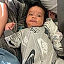 Dandre is registered to the contest to win money with this photo: baby, blanket, child, clothing, cozy, curious, cute, fabric, face, hand, indoor, infant, light, nike, onesie, person, portrait, skin, sleepwear, soft