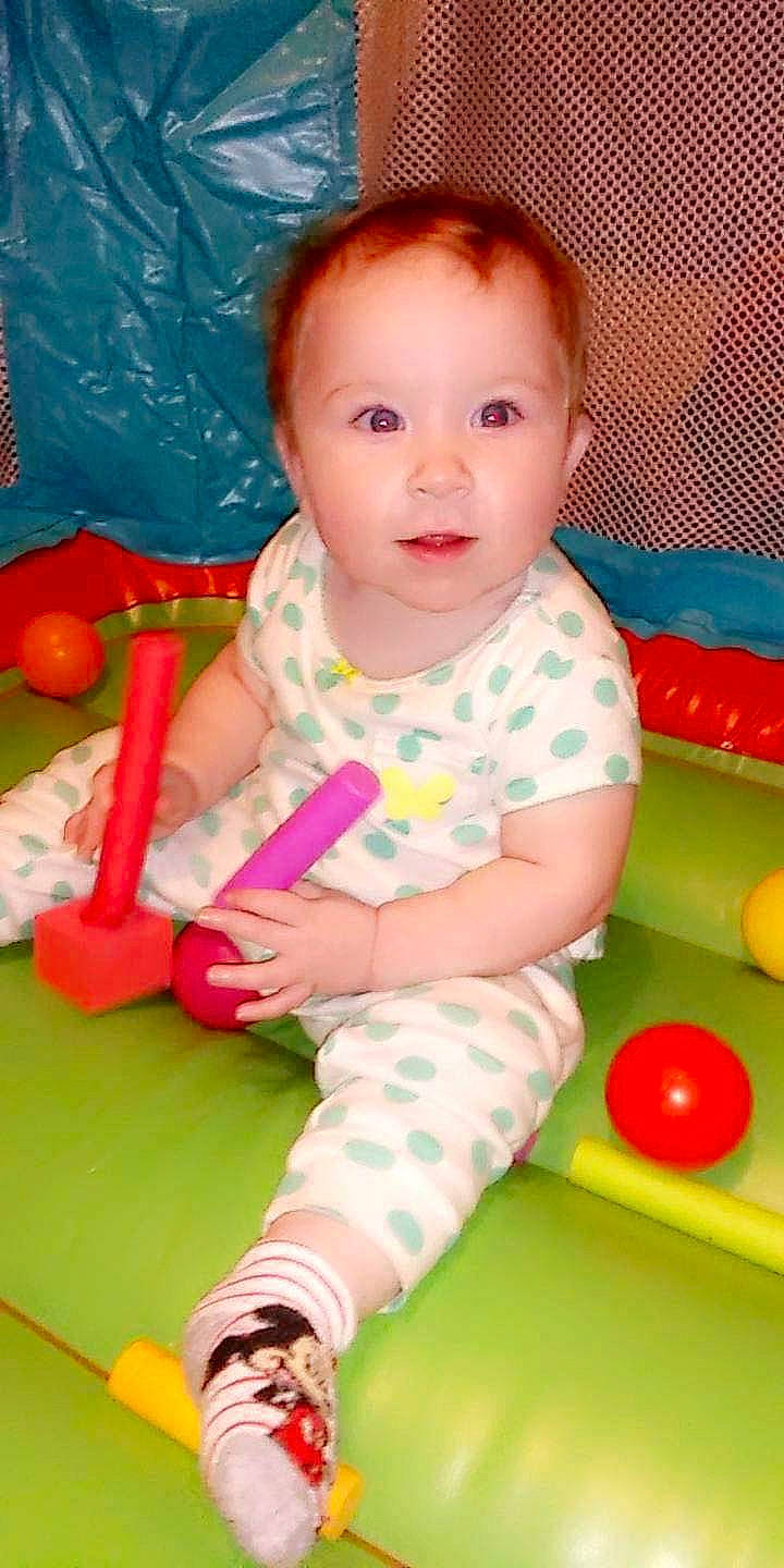 Aubrey is registered to the contest to win money with this photo: arm, baby, baby_playing_with_toys, baby_toddler_clothing, cheek, child, face, facial_expression, flooring, fun, happy, head, human_body, leisure, nose, people, person, product, skin, standing