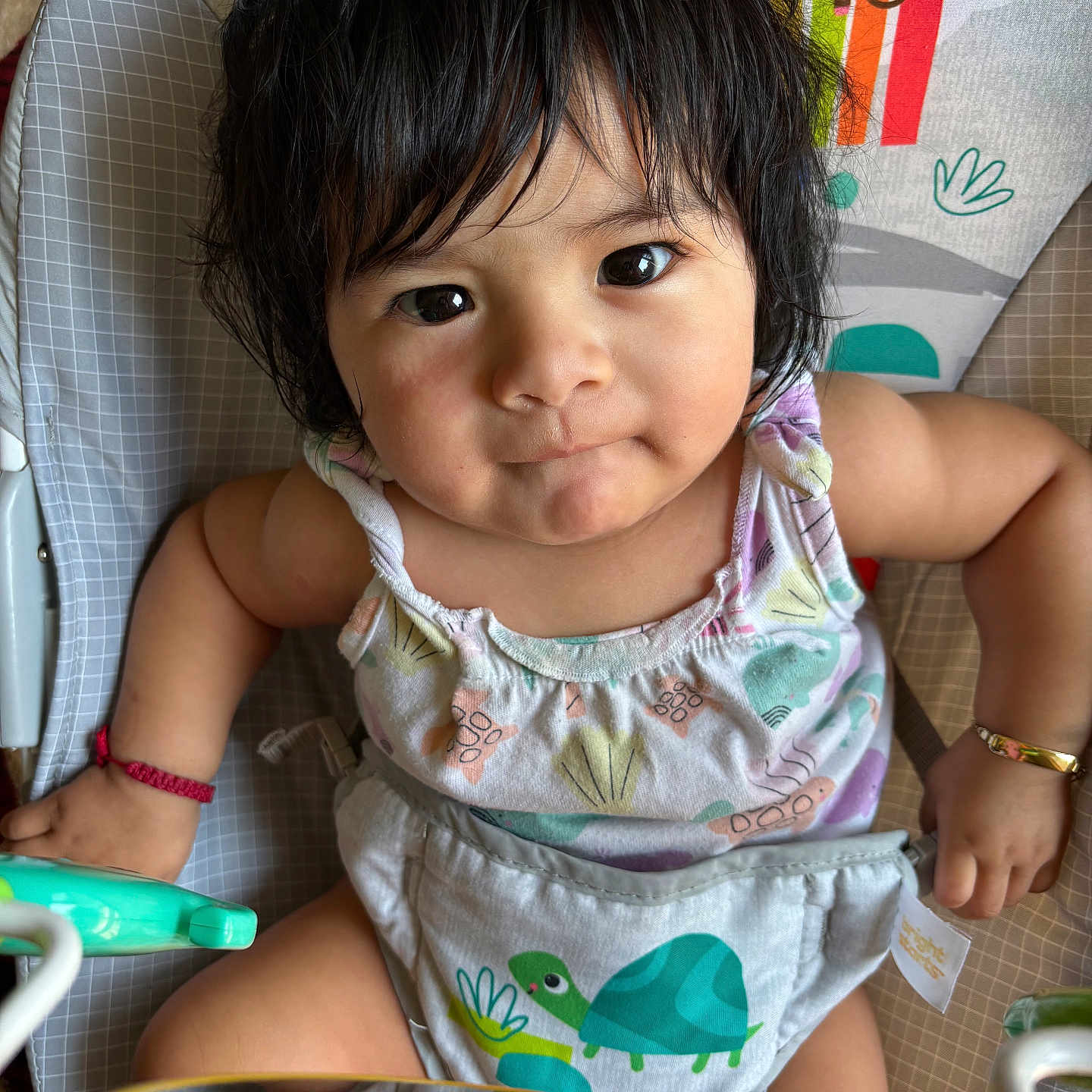 Lindsay Reyes is registered to the contest to win money with this photo: animal_print, baby, baby_seat, bracelet, child, close_up, clothing, colorful, cute, dark_hair, expression, face, indoors, infant, looking_at_camera, playful, portrait, reflection, sitting, toddler