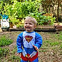 Liam participe au concours pour gagner de l'argent avec cette photo : blue_clothing, child, costume, cute, daylight, footwear, garden, grass, greenery, happy, nature, outdoor, person, plants, playful, smiling, super_baby, toddler, wooden_planter, yard