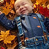 baby, smiling, fall, autumn_leaves, overalls, blue_clothing, outdoor, nature, child, cute, sleeping, seasonal, happy, portrait, infant, relaxing, colorful, leaf_litter, casual_clothing, peaceful