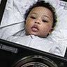 Milani joined the competition — help win amazing prizes! baby, face, camera, digital_screen, recording, zoom_lens, infant, closeup, technology, portrait, child, black_hair, expression, device, lens, monitor, focus, indoor, cute, snapshot