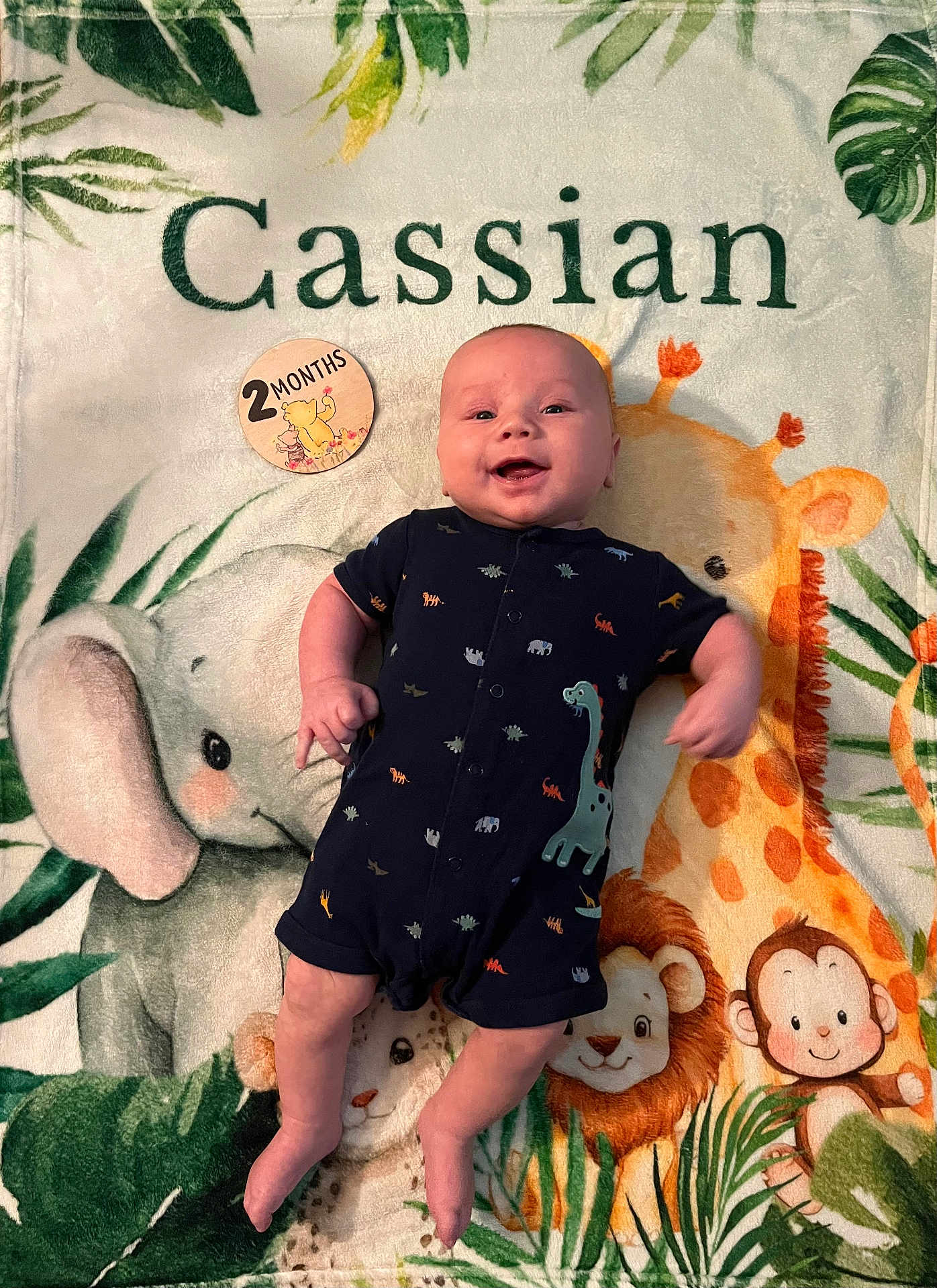 Cassian joined the competition — help win amazing prizes! baby, infant, smiling, blanket, animal_print, elephant, giraffe, lion, monkey, milestone_badge, 2_months, clothing, romper, cute, lying_down, portrait, child, colorful, happy, indoors