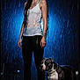 Reich participe au concours pour gagner de l'argent avec cette photo : woman, dog, rain, wet_clothing, tank_top, black_leggings, sneakers, tattoo, long_hair, outdoor, night, blue_light, water_droplets, pet, animal, standing, calm, portrait, companion, storm