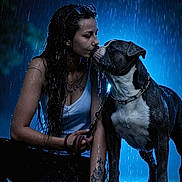 Reich participe au concours pour gagner de l'argent avec cette photo : woman, dog, rain, wet_hair, tattoo, blue_lighting, night, outdoor, leash, closeup, affection, pet, animal, portrait, love, water_drops, dark_background, casual_clothing, bond, emotion