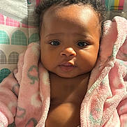 Blessyn joined the competition — help win amazing prizes! baby, infant, child, pink_robe, curly_hair, face, eyes, sunlight, indoor, colorful_background, rainbow, soft_texture, cute, portrait, young_child, warm_light, expression, skin, clothing, diaper