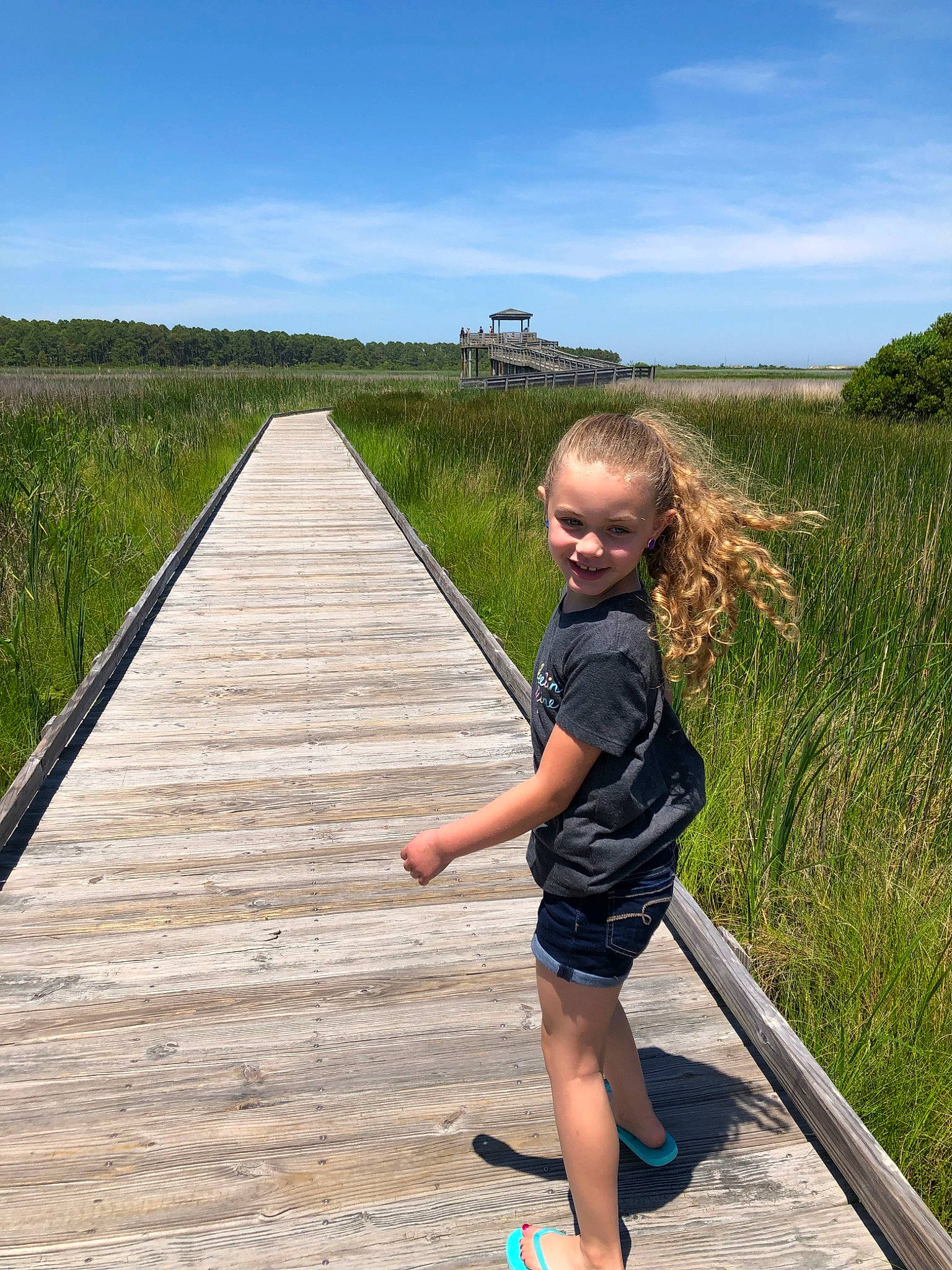 Miya is registered to the contest to win money with this photo: beach, boardwalk, child, fun, grass, joy, leisure, nonbuilding_structure, person, recreation, summer, toddler, tourism, tree, vacation, walking, walkway, water
