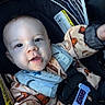 baby, infant, child, car_seat, portrait, smiling, happy, face, eyes, mouth, blanket, clothing, harness, seatbelt, safety_strap, vehicle, indoor, close_up, patterned_fabric, photography