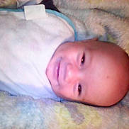 Bentley is registered to the contest to win money with this photo: baby, blanket, child, closeup, comfort, cozy, cute, face, happy, head, indoors, infant, lying_down, portrait, resting, smiling, soft, toddler, warm, young