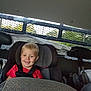 Jaxson is registered to the contest to win money with this photo: child, toddler, car_seat, seat_belt, smile, blonde_hair, vehicle_interior, backseat, headrest, newspaper, metal_grid, stroller, fabric, portrait, happy, candid, window, safety, seat, person