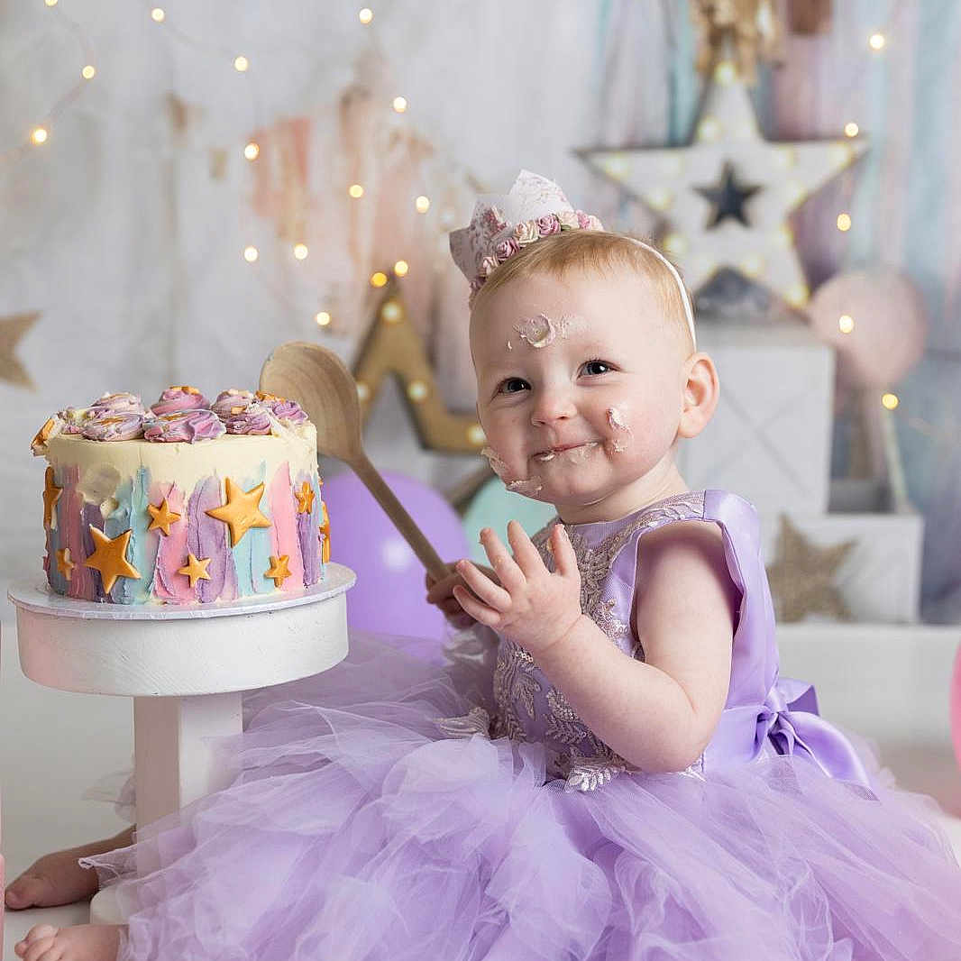 Matilda is registered to the contest to win money with this photo: baby, birthdaycake, birthdayparty, cake, clothing, costume, cream, dessert, dress, face, food, fun, head, icing, party, people, person, photography, portrait, sitting
