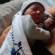 Cédric a rejoint le concours — aidez-le/la à gagner de superbes lots ! newborn, baby, infant, sleeping, blanket, hat, arm, person, resting, indoor, cozy, soft_lighting, cute, tender, human, newborn_baby, child, family, comfort, peaceful