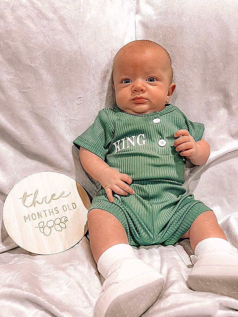 Bear is registered to the contest to win money with this photo: baby, baby_toddler_clothing, cheek, child, comfort, face, foot, happy, head, human, linens, pattern, person, pink, sitting, skin, sleeve, sock, textile, thigh