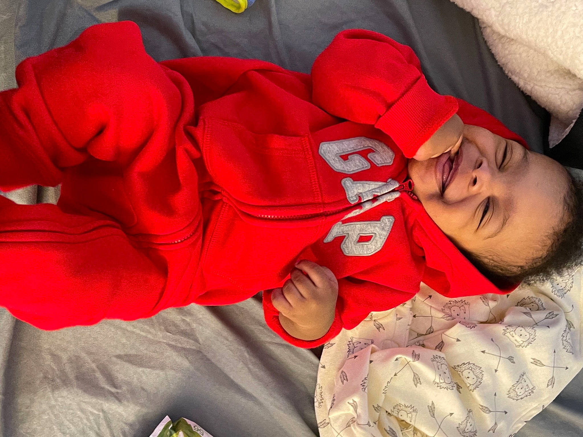 Braiden is registered to the contest to win money with this photo: arm, baby_toddler_clothing, comfort, finger, glasses, hand, happy, headgear, human_body, leg, mouth, muscle, orange, outerwear, person, pink, skin, sleeve, smile, textile