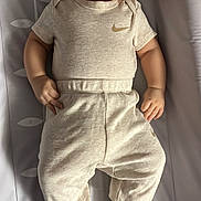 Adam a rejoint le concours — aidez-le/la à gagner de superbes lots ! baby, bedroom, changing_pad, child, clothing, comfort, curious_expression, cute, face, footed_pajamas, hands, head, indoors, infant, lying_down, nike_logo, onesie, pants, skin, soft_lighting