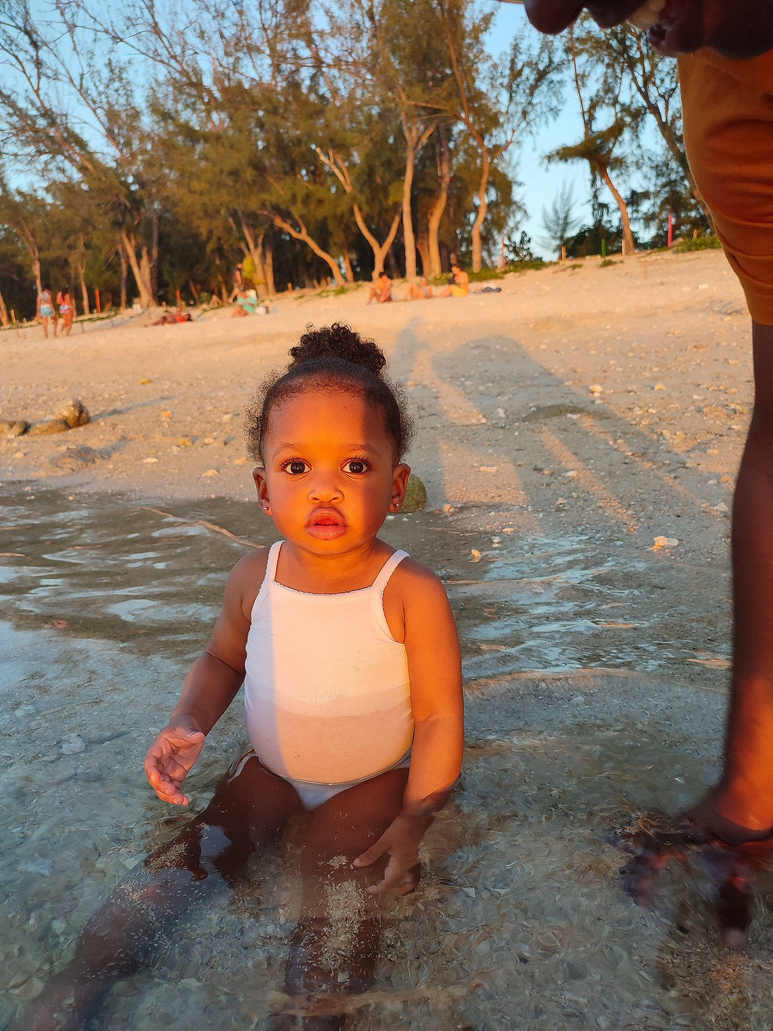 Ella participe au concours pour gagner de l'argent avec cette photo : barefoot, bathing, beach, chest, flash_photography, fun, happy, human_body, leisure, people_in_nature, people_on_beach, person, sand, sky, sunlight, swimwear, thigh, toddler, tree, trunk