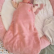 Noémie participe au concours pour gagner de l'argent avec cette photo : baby, sleeping, blanket, pink, plush_toy, playpen, bedroom, soft, peaceful, infant, child, fabric, pattern, comfort, cozy, head, face, hand, pillow, bed