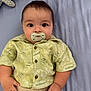 baby, bed, blanket, child, clothing, cute, expression, eyes, face, hand, indoors, infant, knitted_toy, lying_down, pacifier, pants, portrait, shirt, soft_toy, young