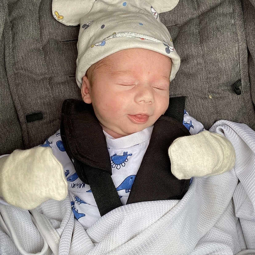Harry is registered to the contest to win money with this photo: baby, blanket, car_seat, child, clothing, cozy, cute, gray, hat, indoors, infant, mickey_mouse, mittens, newborn, peaceful, portrait, resting, sleeping, soft, white