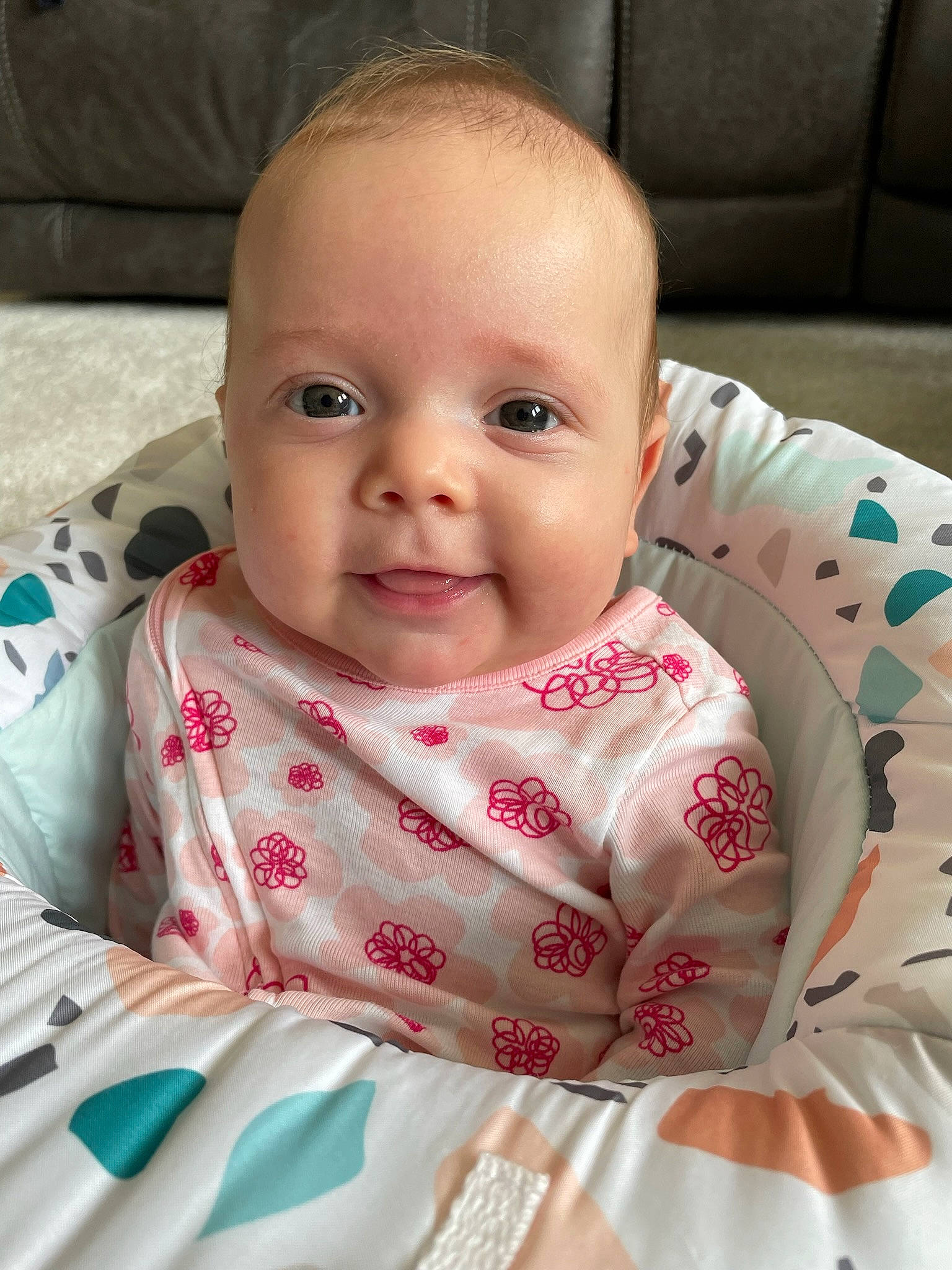 Charley is registered to the contest to win money with this photo: baby, baby_toddler_clothing, cheek, child, comfort, eye, eyebrow, face, facial_expression, happy, iris, linens, lip, nose, pattern, person, sitting, skin, sleeve, smile
