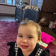 Aela joined the competition — help win amazing prizes! baby, black_shirt, book, cheeks, child, closeup, face, happy, hardwood_floor, indoor, living_room, pigtails, pink_jacket, playpen, playtime, rug, smile, toddler, toy, window